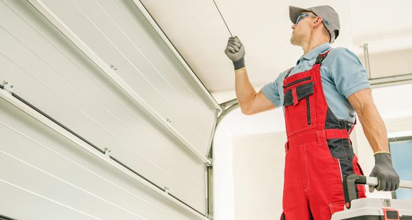 Modern Automatic Garage Doors Installation Performed by Professional Caucasian Installer. Residential Automation.